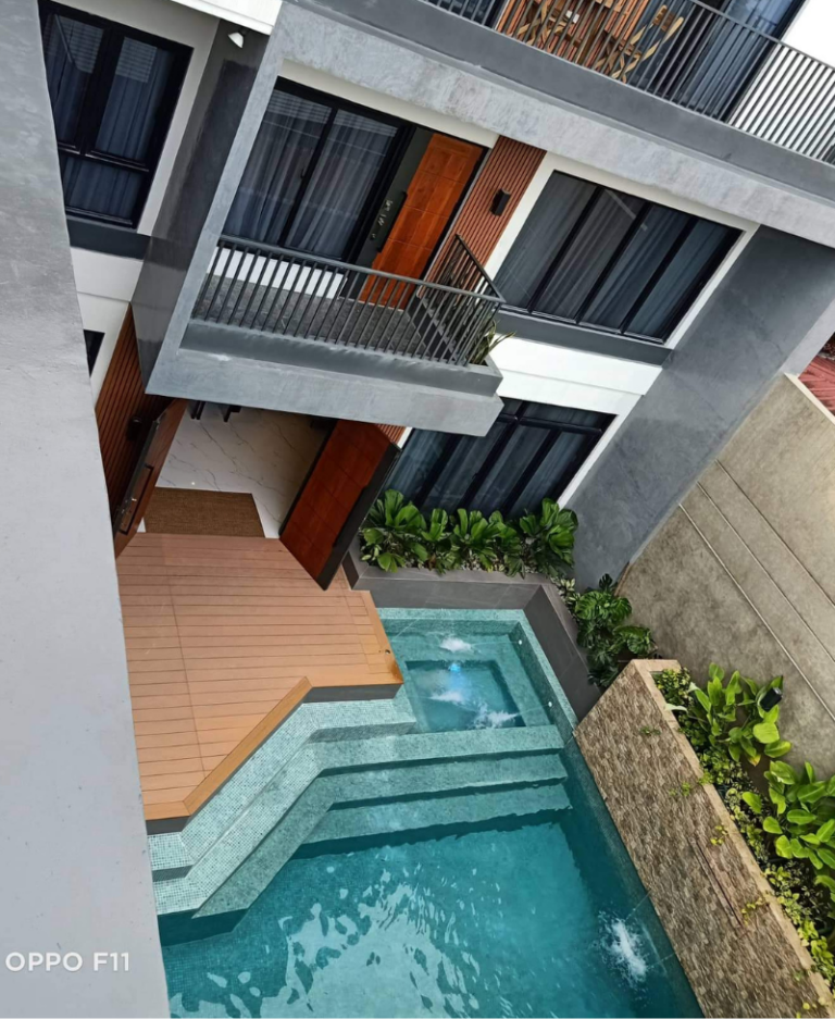 Contemporary three-storey home in Quezon City with a private swimming pool, modern balconies, and elegant outdoor living space.